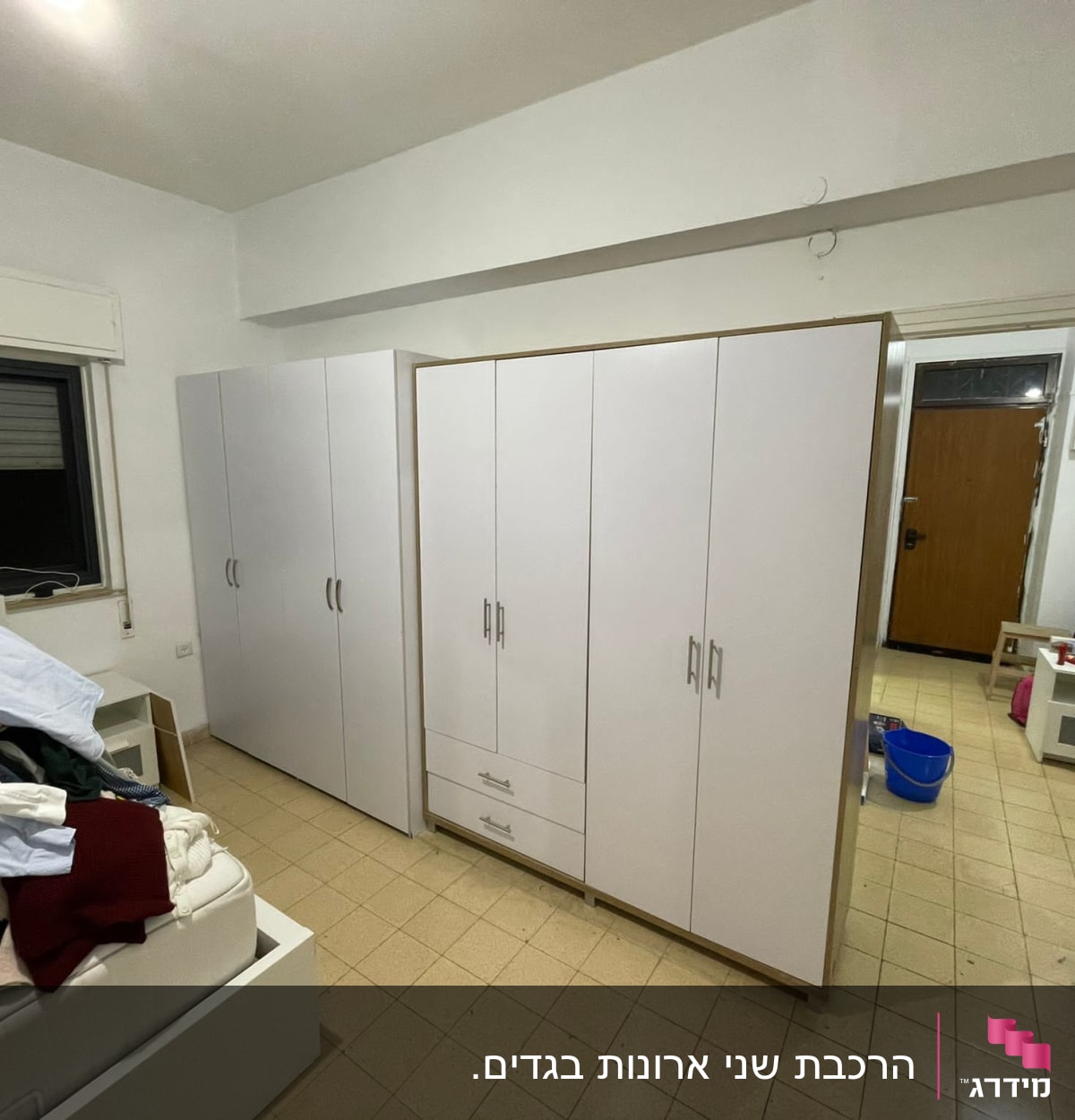 ארון בגדים לבן עם ידיות מתכת בחדר שינה